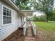 Side entrance of the home includes a wooden ramp and a covered porch, enhancing accessibility and outdoor enjoyment at 11704 Orange Grove Ter, Riverview, FL 33569