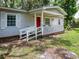 Charming single-story home with a quaint front porch and a bright red front door at 11704 Orange Grove Ter, Riverview, FL 33569