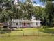 Quaint single-story home with a fenced yard, mature trees, and a welcoming front porch at 11704 Orange Grove Ter, Riverview, FL 33569