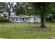 Charming home with a red front door and large trees in the front yard at 11704 Orange Grove Ter, Riverview, FL 33569