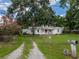 Inviting home featuring a charming exterior with a well-kept lawn, mature trees, and a gated driveway at 11704 Orange Grove Ter, Riverview, FL 33569