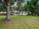 Charming home exterior featuring a well-maintained lawn and a swing, framed by mature trees for added privacy at 11704 Orange Grove Ter, Riverview, FL 33569
