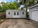 This outdoor shed features white siding, double doors, and a concrete slab foundation, offering practical storage solutions at 11704 Orange Grove Ter, Riverview, FL 33569