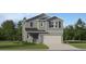 Charming two-story home with a gray exterior, attached garage, and well-maintained landscaping at 11716 Brae Way, Dade City, FL 33525