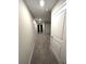 View of the carpeted hallway with white doors and neutral-colored walls leading to other rooms in the house at 11847 Dumaine Valley Rd, Riverview, FL 33579