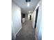 Neutral hallway with carpeted floor, leading to other rooms with white trim and doors in the house at 11847 Dumaine Valley Rd, Riverview, FL 33579