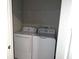 The laundry room features a white washer and dryer with a wire rack above for storage at 11847 Dumaine Valley Rd, Riverview, FL 33579