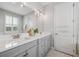 Bright bathroom featuring marble countertop, double sinks, and classic fixtures at 12121 Rustic River Way, Tampa, FL 33635