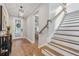 Inviting foyer with wood floors, a decorative front door, and a staircase leading to the second floor at 12121 Rustic River Way, Tampa, FL 33635