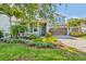 Inviting home featuring a paver driveway, beautiful flower beds, and manicured landscaping at 12121 Rustic River Way, Tampa, FL 33635