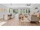Bright living and dining area with hardwood floors, neutral furnishings and large windows overlooking the patio at 12121 Rustic River Way, Tampa, FL 33635