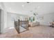 Loft space with carpet, a wrought iron railing, and a view of the downstairs living area at 12121 Rustic River Way, Tampa, FL 33635