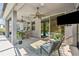 Covered patio is furnished with a ceiling fan, outdoor seating and tv overlooking the pool at 12121 Rustic River Way, Tampa, FL 33635