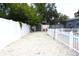 Gravel backyard featuring a white fence surrounding the pool, and a storage shed at 1317 S Betty Ln, Clearwater, FL 33756