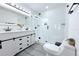 Modern bathroom with a glass shower, gray tile floors, and a white vanity with black hardware at 1317 S Betty Ln, Clearwater, FL 33756