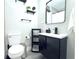 Modern bathroom with a black vanity, open shelving, and matte black fixtures at 1317 S Betty Ln, Clearwater, FL 33756