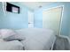 Light blue bedroom with television, luxury vinyl plank flooring, and a double-door closet at 1317 S Betty Ln, Clearwater, FL 33756