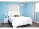Cozy bedroom with a queen bed, white bedding, a side table, and light blue walls at 1317 S Betty Ln, Clearwater, FL 33756
