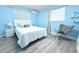 Light-filled bedroom with light blue walls, a queen bed, and modern minimalist decor at 1317 S Betty Ln, Clearwater, FL 33756
