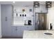 Kitchen featuring gray cabinets, stainless steel refrigerator and a coffee bar area at 1317 S Betty Ln, Clearwater, FL 33756