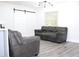 Comfortable living area with gray sofa and chair with vinyl flooring and natural light at 1317 S Betty Ln, Clearwater, FL 33756