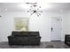 Comfortable living room showcasing stylish light fixture and dark gray sofas at 1317 S Betty Ln, Clearwater, FL 33756