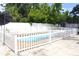 Beautiful in-ground pool with a white fence and a stone patio for outdoor enjoyment at 1317 S Betty Ln, Clearwater, FL 33756