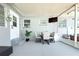 Enclosed porch boasts dining set, mini fridge, and outdoor access to the fenced-in back yard at 1317 S Betty Ln, Clearwater, FL 33756