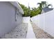 View of a clean side yard featuring fresh gravel and white fencing at 1317 S Betty Ln, Clearwater, FL 33756