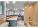 Well-lit bathroom features a wide mirror above a vanity, with shower-tub combination in the corner at 1363 Cottage Grove Rd, Tarpon Springs, FL 34689