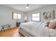 Bright bedroom featuring hardwood floors, a ceiling fan, and two large windows at 1363 Cottage Grove Rd, Tarpon Springs, FL 34689