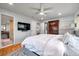 Comfortable bedroom featuring hardwood floors, a ceiling fan, and ensuite bathroom at 1363 Cottage Grove Rd, Tarpon Springs, FL 34689