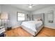Cozy bedroom featuring hardwood floors, a ceiling fan, and a large window at 1363 Cottage Grove Rd, Tarpon Springs, FL 34689