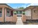 View of the home's front entrance, which features brick pillars with potted plants and a stepping stone walkway at 1363 Cottage Grove Rd, Tarpon Springs, FL 34689