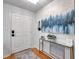 Bright entryway features a white door, modern console table, and vibrant abstract artwork creating a welcoming ambiance at 1363 Cottage Grove Rd, Tarpon Springs, FL 34689