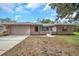 Charming single-story brick home featuring a spacious driveway and attached two-car garage at 1363 Cottage Grove Rd, Tarpon Springs, FL 34689