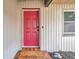 The house's front entrance features a red door and a small tiled porch area with a welcome mat at 1363 Cottage Grove Rd, Tarpon Springs, FL 34689