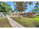 Charming one-story brick home with a well-maintained lawn and mature trees at 1363 Cottage Grove Rd, Tarpon Springs, FL 34689