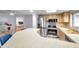 Bright kitchen features stainless steel appliances, wooden cabinetry, and a breakfast bar for casual dining at 1363 Cottage Grove Rd, Tarpon Springs, FL 34689