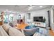 Inviting living room featuring hardwood floors, a ceiling fan, and ample natural light perfect for relaxing or entertaining guests at 1363 Cottage Grove Rd, Tarpon Springs, FL 34689
