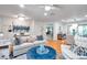 Open living area with hardwood floors featuring a comfortable sofa, stylish decor, and seamless flow to dining area at 1363 Cottage Grove Rd, Tarpon Springs, FL 34689
