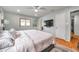 Spacious main bedroom with a ceiling fan, a mounted TV, and ensuite access to a private bathroom at 1363 Cottage Grove Rd, Tarpon Springs, FL 34689