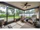 Relaxing screened patio with comfortable seating and ceiling fan, perfect for enjoying the outdoors while avoiding insects at 1363 Cottage Grove Rd, Tarpon Springs, FL 34689