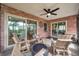 Screened-in patio furnished with outdoor seating, providing a comfortable space to relax with a ceiling fan overhead at 1363 Cottage Grove Rd, Tarpon Springs, FL 34689