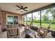 Relaxing screened patio with comfortable seating and ceiling fan, perfect for enjoying the outdoors while avoiding insects at 1363 Cottage Grove Rd, Tarpon Springs, FL 34689