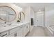 Bathroom featuring double sinks with modern fixtures, large mirrors, and stylish lighting at 18144 Frame Bnd, Land O Lakes, FL 34638
