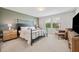 Stylish bedroom featuring a large bed, wooden nightstands, and a comfortable chair with a footrest at 18144 Frame Bnd, Land O Lakes, FL 34638