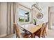 Dining room featuring a wooden table and chairs, a large window with greenery views, and a unique wall clock at 18144 Frame Bnd, Land O Lakes, FL 34638