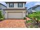 Charming two-story home features a brick driveway, a two-car garage, and well-manicured landscaping at 18144 Frame Bnd, Land O Lakes, FL 34638