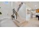 Bright foyer features a staircase with iron railings and views into the kitchen area at 18144 Frame Bnd, Land O Lakes, FL 34638